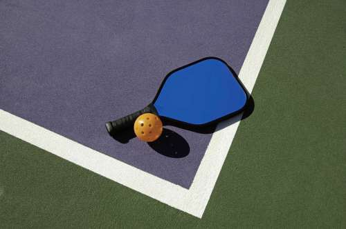 Dreamstime.com
A pickleball paddle and ball, pictured on an outdoor court.