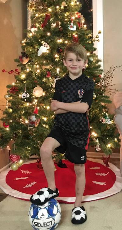 Supplied photo
                                Bepo Malbasa poses in the colours of the Croatian national soccer team in front of the family Christmas tree.