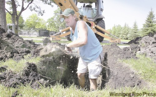 WAYNE.GLOWACKI@FREEPRESS.MB.CA
Dave Watts grabs his shovel at the Shaarey Zedek cemetery to tidy up a fresh grave he has roughed out with a backhoe. He admits being moved to tears at some funerals.