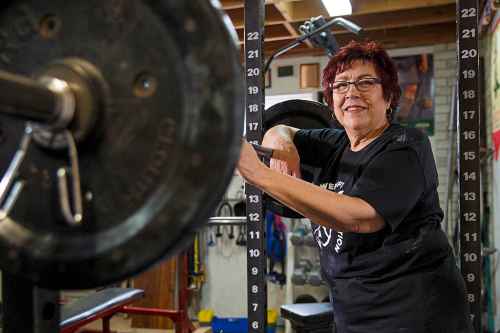 MIKE DEAL / WINNIPEG FREE PRESS
Susan Haywood a record-breaking 70-year-old power lifter works out in her home gym near Teulon.