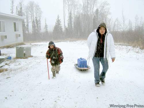 HELEN.FALLDING@FREEPRESS.MB.CA
Nicole Mason, 14, and her brother haul water to their trailer at St. Theresa Point last winter. More than 1,400 homes on northern reserves lack running water.