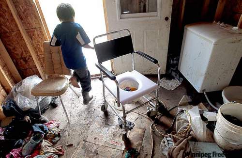 Joe Bryksa / winnipeg free press archives
A child runs past a makeshift toilet in a house in Garden Hill First Nation.