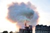 Flames and smoke rise as the spire on Notre Dame cathedral collapses in Paris, Monday, April 15, 2019. Massive plumes of yellow brown smoke is filling the air above Notre Dame Cathedral and ash is falling on tourists and others around the island that marks the center of Paris. (AP Photo/Diana Ayanna)