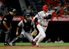 Los Angeles Angels designated hitter Shohei Ohtani, right, hits a ground out to second, with Pittsburgh Pirates catcher Jacob Stallings, center, and umpire Jeff Nelson, left, watching during the third inning of a baseball game in Anaheim, Calif., Monday, Aug. 12, 2019. (AP Photo/Alex Gallardo)