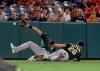 Oakland Athletics left fielder Chad Pinder, left, and third baseman Matt Chapman, right, just miss a fly ball that fell between them for an RBI double by Los Angeles Angels' Brian Goodwin to score Matt Thaiss during the fifth inning of a baseball game in Anaheim, Calif., Tuesday, Sept. 24, 2019. (AP Photo/Alex Gallardo)