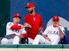 Texas Rangers' Kyle Bird, left, shakes hands with Chris Martin, center, as Jesse Chavez watches play in the third inning of a baseball game against the Seattle Mariners in Arlington, Texas, Tuesday, July 30, 2019. Martin was traded to the Atlanta Braves for a pitching prospect. (AP Photo/Tony Gutierrez)
