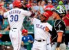 Texas Rangers' Nomar Mazara (30) is congratulated by Elvis Andrus, center, after hitting a two-run home run that scored Andrus off of Chicago White Sox starting pitcher Reynaldo Lopez during the first inning of a baseball game Friday, June 21, 2019, in Arlington, Texas. White Sox catcher James McCann is at right. (AP Photo/Jeffrey McWhorter)