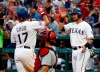 Texas Rangers' Shin-Soo Choo, left, and Jeff Mathis, right, celebrate Choo's two-run home run that scored Mathis as St. Louis Cardinals catcher Yadier Molina, kneels by the plate in the second inning of a baseball game in Arlington, Texas, Friday, May 17, 2019. (AP Photo/Tony Gutierrez)