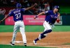 Texas Rangers third base coach Tony Beasley (37) waves Hunter Pence (24) home as Pence scores on a Nomar Mazara double during the sixth inning of a baseball game against the Seattle Mariners in Arlington, Texas, Tuesday, May 21, 2019. (AP Photo/Tony Gutierrez)