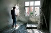 A person inspects the damage on a building hit by a mortar fired from inside Syria, in Akcakale, Sanliurfa province, southeastern Turkey, Sunday, Oct. 13, 2019. Incoming shells fired from northeastern Syria hit the house earlier on Sunday. Two residents were at the house and were evacuated. (AP Photo/Lefteris Pitarakis)