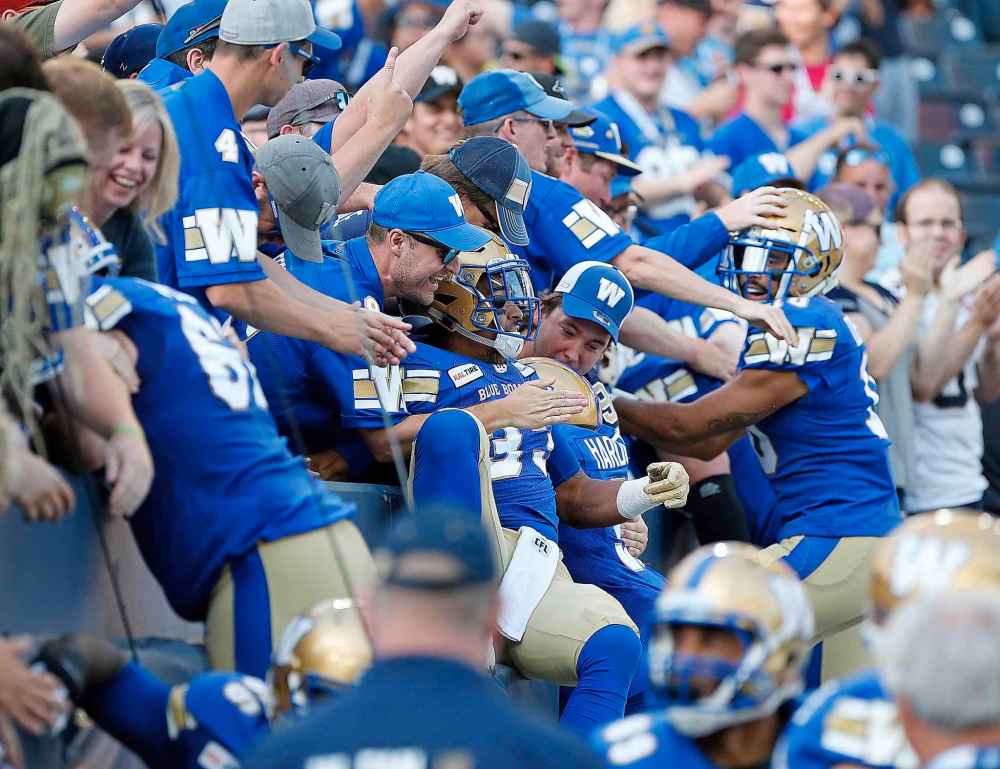 John Woods / THE CANADIAN PRESS FILES
Blue Bombers' Andrew Harris celebrates a touchdown with Bombers fans during a game against the Toronto Argonauts last Friday. Despite a 29-year championship drought, the Bombers have continued posting operating profits for years.