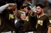 San Diego Padres' Hunter Renfroe, center, reacts with teammates Manny Machado, left, and Austin Hedges, right, after hitting a home run during the fourth inning of a baseball game against the Miami Marlins Friday, May 31, 2019, in San Diego. (AP Photo/Gregory Bull)