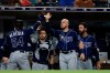 Tampa Bay Rays' Guillermo Heredia (54) is greeted by teammates after scoring off a fly ball by Jesus Aguilar during the seventh inning of a baseball game against the San Diego Padres Monday, Aug. 12, 2019, in San Diego. (AP Photo/Gregory Bull)