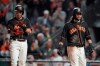 San Francisco Giants' Mauricio Dubon, left, and Brandon Crawford, right, both score runs on a triple by Donovan Solano against the Miami Marlins during the seventh inning of a baseball game Saturday, Sept. 14, 2019, in San Francisco. (AP Photo/Tony Avelar)