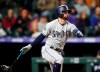 San Diego Padres' Greg Garcia hits a grounder with the bases loaded to drive in the go-ahead run in the ninth inning of the team's baseball game against the Colorado Rockies on Saturday, May 11, 2019, in Denver. San Diego won 4-3. (AP Photo/David Zalubowski)
