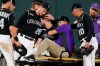 Colorado Rockies third baseman Nolan Arenado, left, consoles center fielder David Dahl, who suffered an injury to his right leg while catching a fly ball hit by San Francisco Giants' Scooter Gennett during the sixth inning of a baseball game Friday, Aug. 2, 2019, in Denver. (AP Photo/David Zalubowski)