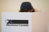 A woman marks her ballot behind a privacy barrier in the riding of Vaudreuil-Soulanges, west of Montreal, on election day, Monday, Oct. 19, 2015. An international body that specializes in monitoring elections is skipping this year's Canadian election due to limited resources despite questions and potential concerns about the role of third-party groups, cybersecurity and social media in the campaign. THE CANADIAN PRESS/Graham Hughes