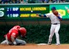 Chicago Cubs second baseman Addison Russell, right, throws out Cincinnati Reds' Phillip Ervin at first after forcing out Yasiel Puig at second during the eighth inning of a baseball game in Chicago, Wednesday, July 17, 2019. (AP Photo/Nam Y. Huh)