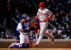 Philadelphia Phillies' J.T. Realmuto, right, crosses home plate after hitting a solo home run against the Chicago Cubs during the 10th inning of a baseball game, Monday, May 20, 2019, in Chicago. (AP Photo/Kamil Krzaczynski)