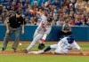 Toronto Blue Jays' Randall Grichuk safe at third base on a passed ball to the plate as Atlanta Braves' Josh Donaldson tries to handle throw from his catcher in the fifth inning of their Interleague MLB baseball game in Toronto Wednesday August 28, 2019. THE CANADIAN PRESS/Fred Thornhill