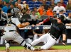 Miami Marlins' Garrett Cooper, right, slides into home next to Pittsburgh Pirates catcher Elias Diaz during the fourth inning of a baseball game Saturday, June 15, 2019, in Miami. (AP Photo/Wilfredo Lee)