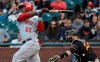 Cincinnati Reds' Yasiel Puig, left, hits a two-run home run in front of San Francisco Giants catcher Stephen Vogt during the first inning of a baseball game in San Francisco, Saturday, May 11, 2019. (AP Photo/Jeff Chiu)