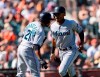 Miami Marlins' Magneuris Sierra, right, celebrates with Curtis Granderson (21) after he scores a run against the San Francisco Giants in the seventh inning of a baseball game in San Francisco, Sunday, Sept. 15, 2019. (AP Photo/John Hefti)