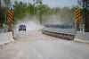 A car crosses a new bridge on Freedom Road just outside Shoal Lake 40 First Nation on Thursday. (John Woods photos / The Canadian Press)