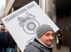 A CN rail worker holds up a sign outside CN headquarters in Montreal, Tuesday, Nov. 26, 2019. THE CANADIAN PRESS/Graham Hughes