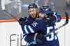 Kevin Hayes (left) and Mark Scheifele celebrate Hayes' first goal as a Jet when he scored into an empty net late in the third period. (John Woods / The Canadian Press)