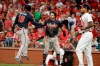 Atlanta Braves' Dansby Swanson, center, and Rafael Ortega, left, celebrate in front of St. Louis Cardinals relief pitcher Carlos Martinez after scoring during the ninth inning in Game 3 of a National League Division Series on Sunday, Oct. 6, 2019, in St. Louis. (AP Photo/Charlie Riedel)