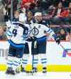 (AP Photo/Duane Burleson)
Winnipeg Jets defenseman Dustin Byfuglien, centre, celebrates his game-winning goal with Andrew Copp  and Adam Lowry during the third period against the Detroit Red Wings, Friday in Detroit.