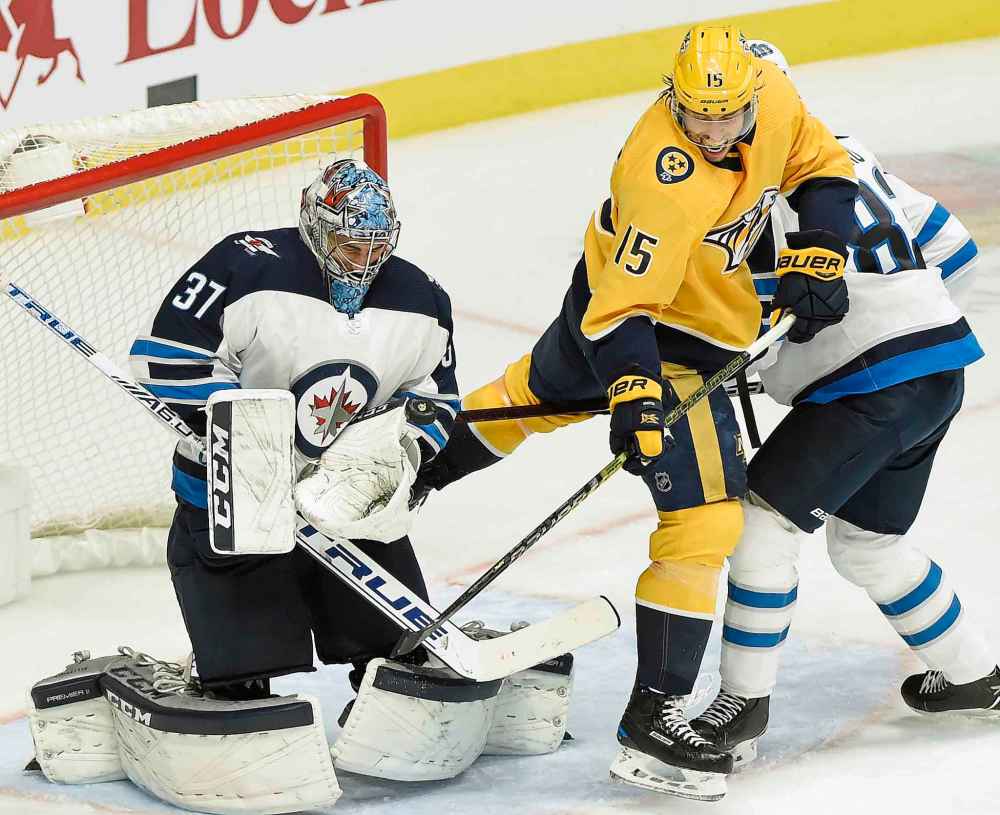 (AP Photo/Mark Zaleski)
Winnipeg Jets goaltender Connor Hellebuyck stops a shot as Nashville Predators right wing Craig Smith looks for a rebound during the second period.