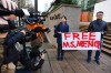 People hold a sign at a B.C. courthouse prior to the bail hearing for Meng Wanzhou, Huawei's chief financial officer on Monday, December 10, 2018. THE CANADIAN PRESS/Jonathan Hayward