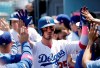 Los Angeles Dodgers' Cody Bellinger gets high-fives in the dugout after scoring on a sacrifice fly ball from Corey Seager during the second inning of a baseball game against the Washington Nationals, Sunday, May 12, 2019, in Los Angeles. (AP Photo/Marcio Jose Sanchez)