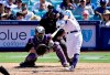 Los Angeles Dodgers' Chris Taylor, right, hits a three-run home run as Colorado Rockies catcher Tony Wolters, left, watches along with home plate umpire Paul Emmel, center, during the seventh inning of a baseball game Sunday, June 23, 2019, in Los Angeles. (AP Photo/Mark J. Terrill)