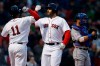 Boston Red Sox's J.D. Martinez, center, celebrates his solo home with teammate Rafael Devers (11) as Texas Rangers' Jeff Mathis, right, stands at home plate during the first inning of a baseball game in Boston, Thursday, June 13, 2019. (AP Photo/Michael Dwyer)