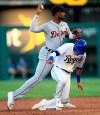 Detroit Tigers second baseman Niko Goodrum, top, forces out Kansas City Royals' Nicky Lopez (1) during the second inning of a baseball game at Kauffman Stadium in Kansas City, Mo., Friday, July 12, 2019. Goodrum had a throwing error on the play that scored Kansas City Royals' Bubba Starling. (AP Photo/Orlin Wagner)