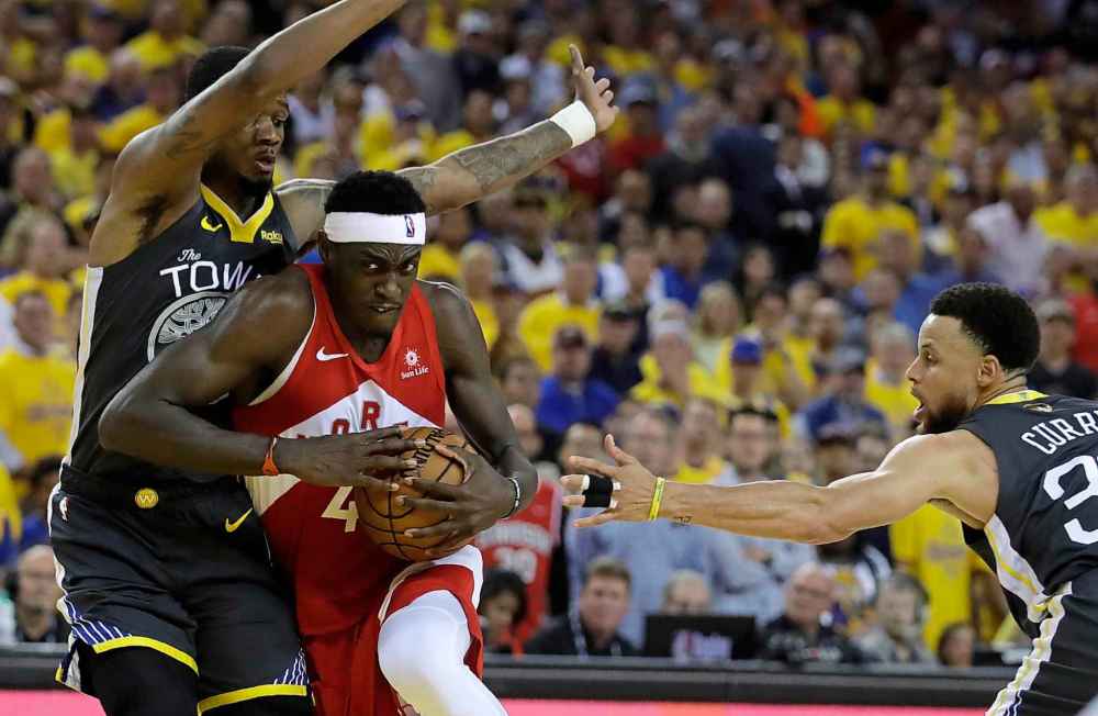 Ben Margot / The Associated Press
Toronto Raptors' Pascal Siakam, centre, drives the ball between Golden State Warriors' Alfonzo McKinnie, left, and Stephen Curry (30) in the second quarter of Game 6.