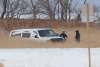 An unmarked white police van is seen at the bottom of a large snow-filled ditch off Highway 417 just south of the Lake Manitoba First Nation. (Wayne Glowacki / Winnipeg Free Press)