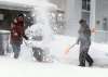 Kim Barrow, with yellow push shovel, is happy that her neighbour on Cormorant Bay, Bob Yamashita, has a gas powered snowblower. (Boris Minkevich / Winnipeg Free Press)