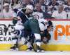 Winnipeg Jets' Mathieu Perreault (85) gets checked by Minnesota Wild's Nick Seeler (36) and Jason Zucker (16) during second period NHL game one playoff action in Winnipeg on Wednesday, April 11, 2018. (John Woods / The Canadian Press)
