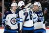 Winnipeg Jets' Jacob Trouba (8), Blake Wheeler (26) and Mark Scheifele (55) celebrate a shorthanded goal by Trouba against the Minnesota Wild during the second period of an NHL hockey game, Tuesday, April 2, 2019, in St. Paul, Minn. (AP Photo/Hannah Foslien)