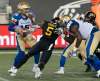 Hamilton Tiger-Cats defensive end Adrian Tracy charges at quarterback Matt Nichols for the sack during the second half on Friday. (Peter Power / Canadian Press files)