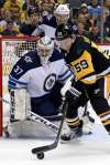 (AP Photo/Gene J. Puskar)
Jets goaltender Connor Hellebuyck stares down Penguins forward Jake Guentzel.