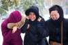 Taranjeet Toor (left), Porie Pedrina, and Kashmere Cleofas band together to battle the wind and snow on the way to a PD day at the Centennial Concert Hall in Winnipeg on Friday. (Mikaela MacKenzie / Winnipeg Free Press)