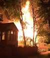 ARLEA ASHCROFT photo
Above left: Officials investigate at the rooming house at 186 Austin St. North Thursday. Above right: The rooming house well involved with flames early Thursday.