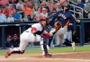 FILE - In this March 12, 2019, file photo, Houston Astros' Carlos Correa heads for home as Washington Nationals catcher Yan Gomes waits for the ball during the third inning of a spring training baseball game in West Palm Beach, Fla. Correa was out. The Astros and Nationals began the year by sharing their Ballpark of the Palm Beaches spring training home. More than 200 days after breaking camp, they'll end the year on the same field with much more at stake. Seven spring training sites currently host two teams, including Camelback Ranch, home of the Los Angeles Dodgers and Chicago White Sox. (AP Photo/Brynn Anderson, File)