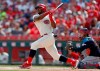 FILE - In this July 6, 2019, file photo, Cincinnati Reds' Yasiel Puig, left, follows through on a two-run home run off Cleveland Indians starting pitcher Shane Bieber during the first inning of a baseball game, in Cincinnati. The Indians bulked up for the playoff race by trading temperamental starter Trevor Bauer before the deadline to Cincinnati in a three-team deal they hope can help them run down the Minnesota Twins. Cleveland, which trails the AL Central by three games but leads the wild-card race, sent Bauer to the Reds for slugger Yasiel Puig and left-hander Scott Moss. The Indians also acquired outfielder Franmil Reyes, lefty Logan Allen and infield prospect Victor Nova from the San Diego Padres, who acquired outfielder Taylor Trammel from the Reds.(AP Photo/Gary Landers, File)