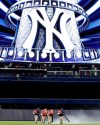 Groundskeepers use leaf blowers to remove water from center field at Yankee Stadium before a baseball game between the New York Yankees and the Baltimore Orioles, Monday, May 13, 2019, in New York. The game was postponed until Wednesday afternoon due to unplayable field conditions. (AP Photo/Kathy Willens)